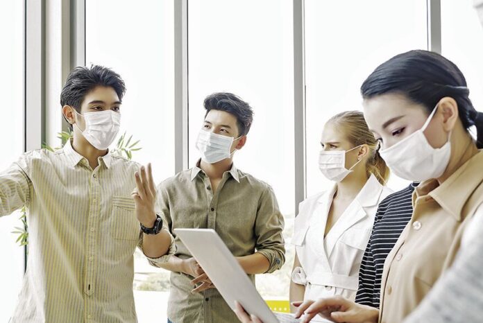 ADOBE STOCK PHOTOA group of office workers are clad in protective face masks
