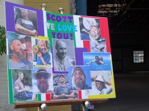 MEMORIES — A poster with photos of Scott Ritchey is displayed at a flower vigil organized in his memory on Artisan Alley Nov. 15.  BEACON PHOTO/MARSHA MCLAUGHLIN