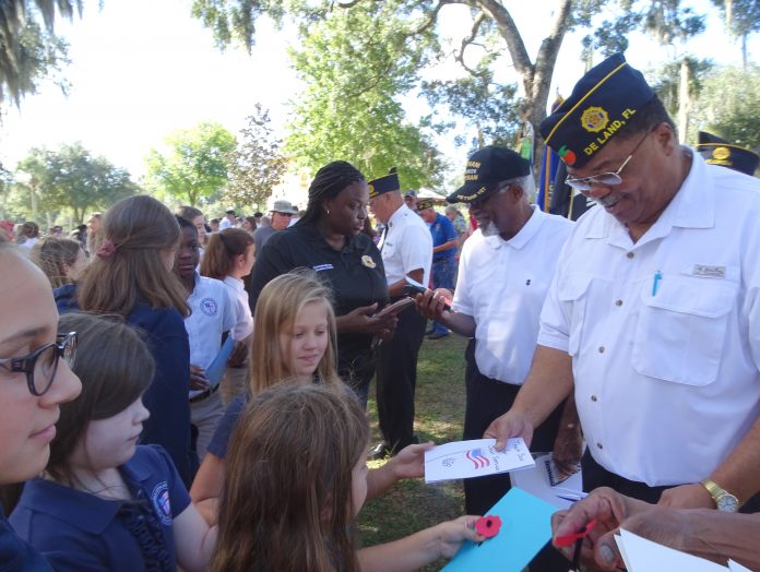 MEMORIALIZED— DeLand City Commissioner Jessica Davis and a group of students from St. Barnabas Episcopal School meet with DeLand veterans at Bill Dreggors Park for DeLand's Memorial Day ceremony in 2019. This was the most recent time Memorial Day was celebrated in-person by the City of DeLand.BEACON PHOTO/MARSHA MCLAUGHLIN