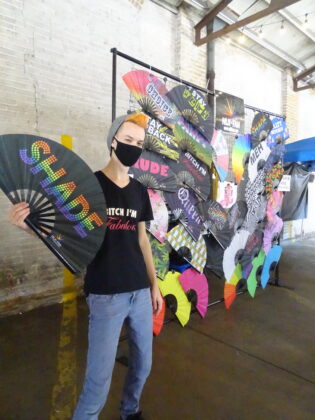 <p><p>One of the vendors, Chris Mistery of Niji Fans, poses with their wares</p></p><p></p>