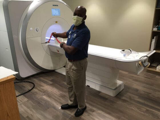 <p><p><strong>THE FORCE IS WITH YOU</strong> — Herman Parker demonstrates the magnetic field created by the MRI machine that he operates. The magnetic power of the device is such that it pulls a pair of steel scissors at the end of the chain toward it. Parker says the magnetic force is powerful enough to stop pacemakers and hearing aids, as well as wipe out credit cards.</p></p><p></p>