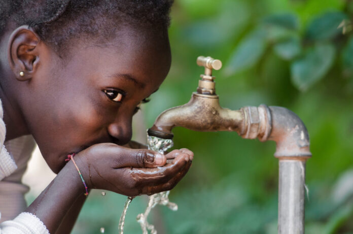 child drinking from tap